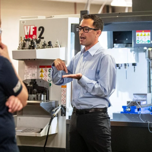 Photo of Michael Gomez at work explaining a machine.