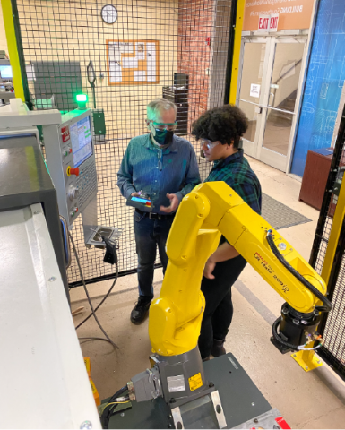 Photo of a student and instructor working on a robotic arm. Photo credit: NIST