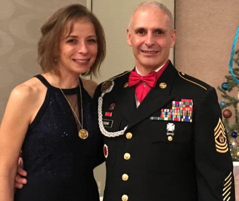 Photo of Litsa Rubina dressed up with her husband in his military dress uniform.