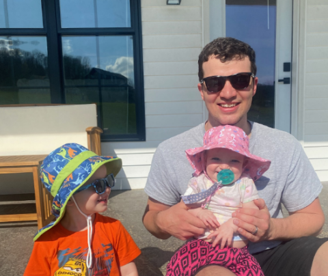 Photo of Josh Krug sitting outside with his son and daughter